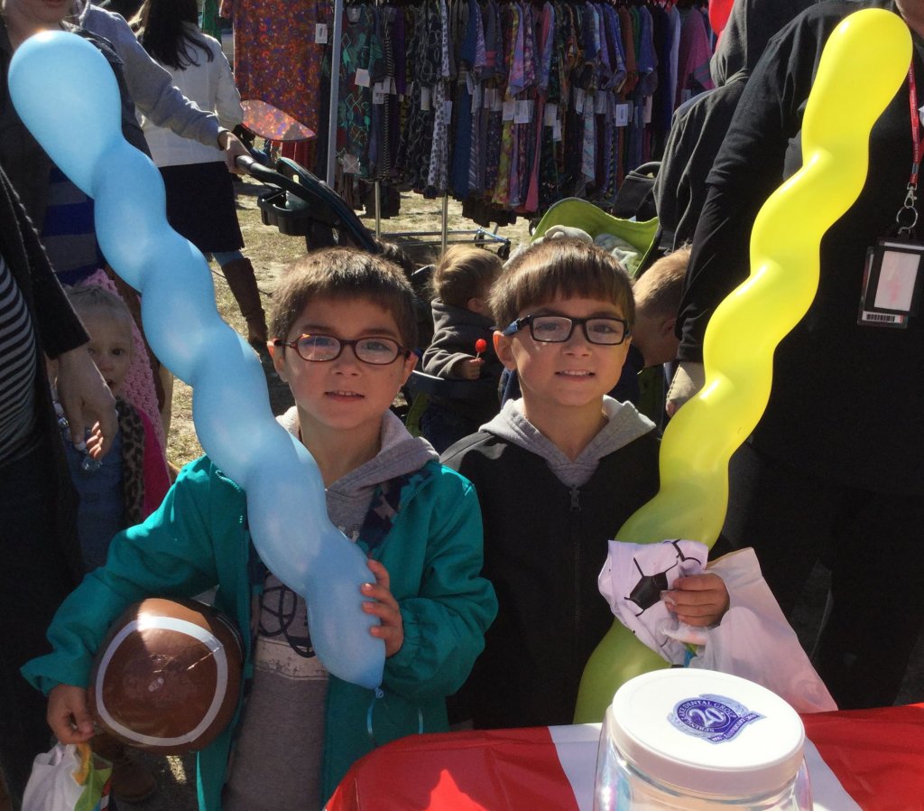Partners in Education event, 2 young children holding a party balloon