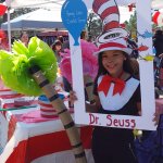 Partners in Education event, a young girl behind a cut out frame