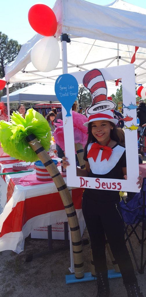 Partners in Education event, a young girl behind a cut out frame