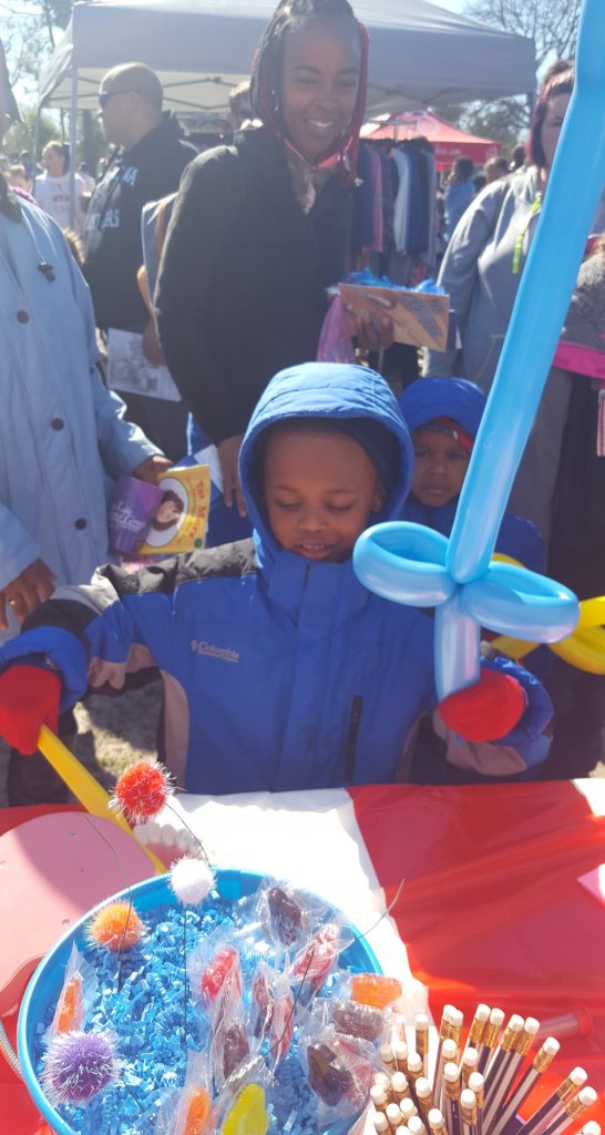 Partners in Education event, a young boy in front of a table with candies